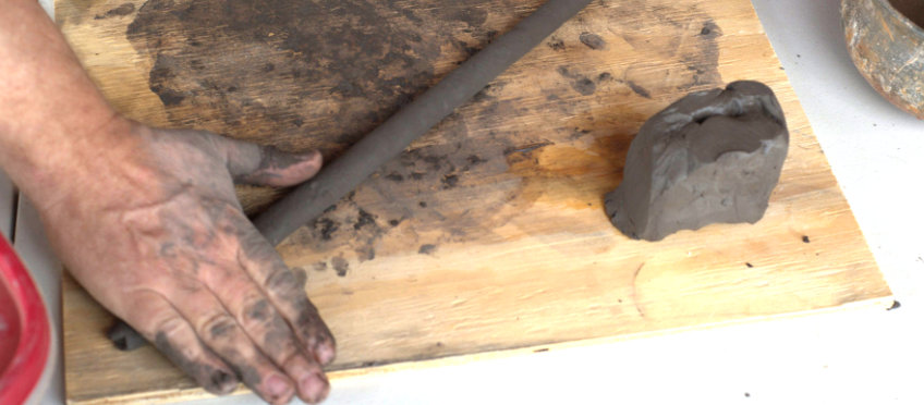 Rolling out a coil of clay.