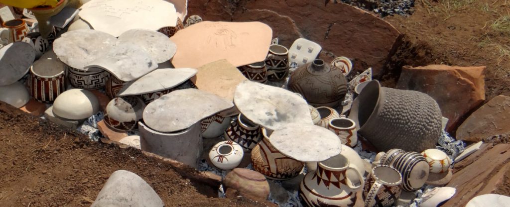 Anasazi trench kiln is loaded with replica pottery