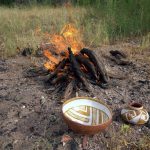 Pottery preheats in front of a fire in preparation to firing